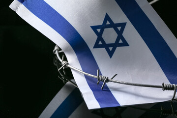 Flag of Israel and barbed wire on dark background. International Holocaust Remembrance Day