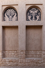 Arabic style window portals in stone wall with ornaments, traditional arabic architecture, Al Fahidi, Dubai, United Arab Emirates.