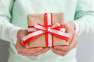 Man with gift box for Valentine's Day on grey background, closeup