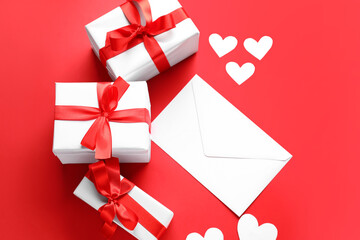 Composition with gift boxes, envelope and paper hearts on red background. Valentine's Day...