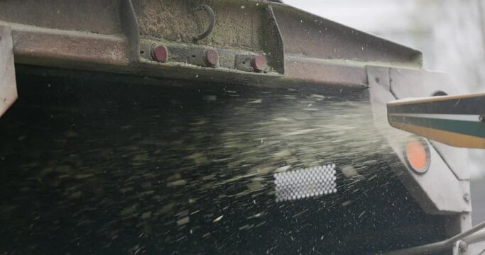 Wood chipper blowing chips into truck bed at 4k 120fps