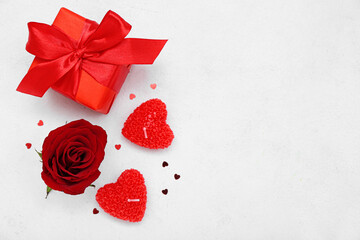 Composition with beautiful candles, gift box and rose flower on light background. Valentine's Day celebration