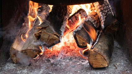 Fire in the fireplace with firewood and coal. Firewood is burning