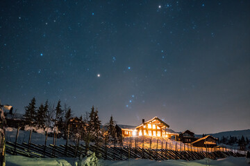 Milky Way stars under Cabin House in Norway. Christmas Night with Snow House Hytte