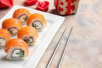 Plate with sushi rolls and chopsticks on grunge background, closeup. Valentine's Day celebration