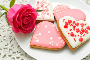Plate of tasty heart shaped cookies and rose flower, closeup. Valentine's Day celebration