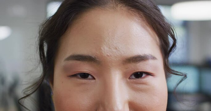 Portrait of asian businesswoman looking at camera in office, slow motion