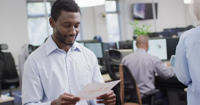 Portrait of happy african american businessman working with colleagues in office, slow motion