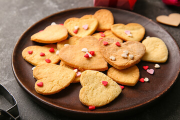 Plate of tasty heart shaped cookies on dark background, closeup. Valentines Day celebration