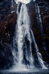Fototapeta na wymiar Closeup Of Mountain Waterfall Cascading Into Water at Sterling Falls, Milford Sound in Fiordland National Park, New Zealand