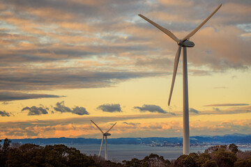 Fototapeta Coastal Wind Turbines Tower above Sea with Dramatic Sunset Sky obraz