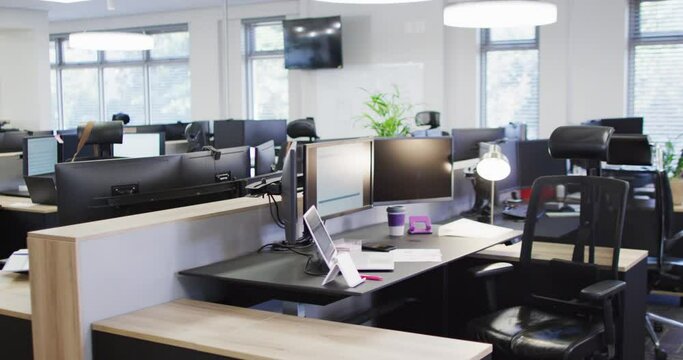 General view of empty modern office with multiple computers, slow motion