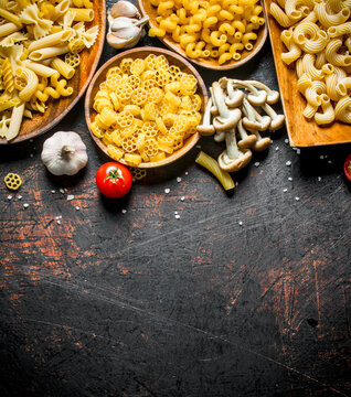 Different types of raw paste on a plate with garlic and mushrooms.