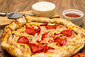 Sausage and vegetable pizza served on round wooden board