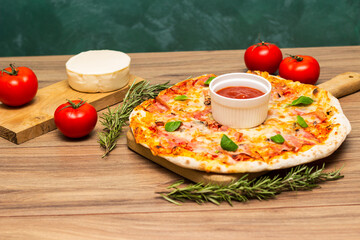 Freshly baked pizza with ham, tomato, and cheese