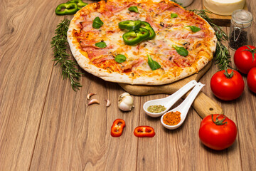 Freshly baked pizza with ham, tomato, and cheese