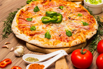 Freshly baked pizza with ham, tomato, and cheese