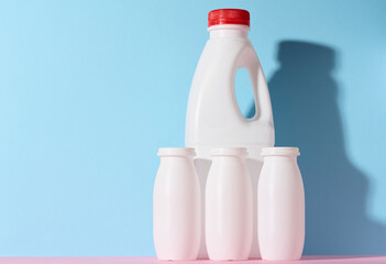 White plastic bottles for yogurt and dairy products on a blue background