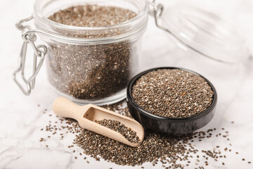 Chia seeds in bowls and spoons on a white marble background. SUPERFOOD and antioxidant. Healthy food concept. Gluten free. Copy space.