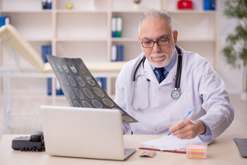 Old male doctor radiologist working in the clinic