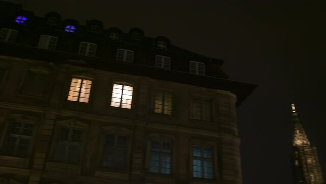 Slow panning to beautiful old bourgeois Haussmannian building in central Strasbourg French city France, housing luxury apartments or offices with lights at night - Cathedrale Notre-Dame de Strasbourg 