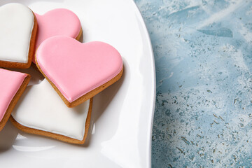 Plate with heart shaped cookies on blue grunge background, closeup. Valentines Day celebration