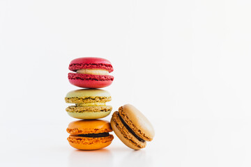 Stack of Red Velvet, Pistachio, Chocolate and Mandarin, and Milk Chocolate Macaron Cookies on White Background