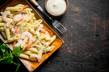 Pasta with shrimp, mint leaves and sauce in bowl.