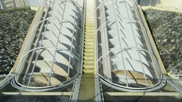 Closeup of grey turning metal screw pumps to pump water from low to high. Also known as Archimedes screw pump or water screw	