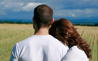 Rear view of couple overlooking farmland.