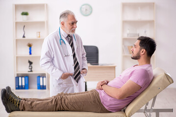 Obraz premium Young male patient visiting old male doctor