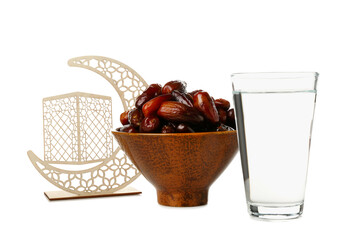Bowl with dates, glass of water and decorative crescent for Ramadan on white background