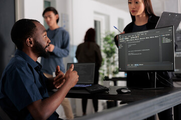 Diverse group of web developers analyzing html code and comparing data script in big data office...