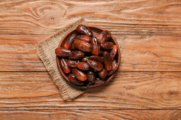Plate with dried dates for Ramadan on wooden background