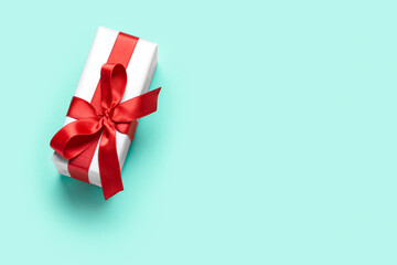 Gift box with beautiful bow on mint background. Valentine's Day celebration