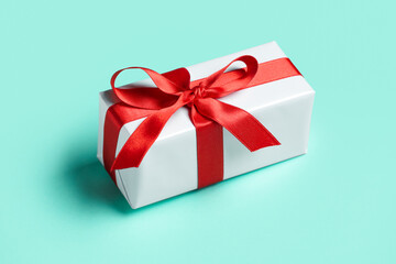Gift box with beautiful bow on mint background. Valentine's Day celebration