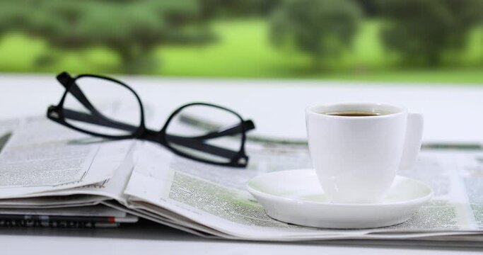 eyeglasses and newspaper with cup of coffee