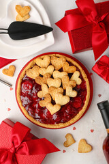 Plate with sweet strawberry pie, cookie hearts and gifts for Valentine's day on white background