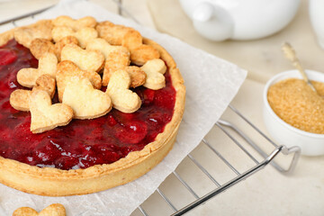Oven rack with sweet strawberry pie, cookie hearts and bowl of brown sugar for Valentine's day on light table