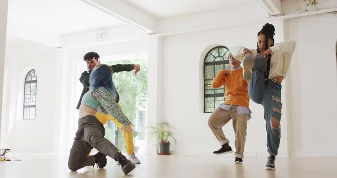 Happy diverse male and female dancers dancing in dance studio, slow motion