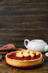 Plate with sweet strawberry pie, cookie hearts and teapot for Valentine's day on wooden table
