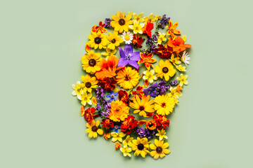 Human head symbol made of summer flowers. World mental health day concept
