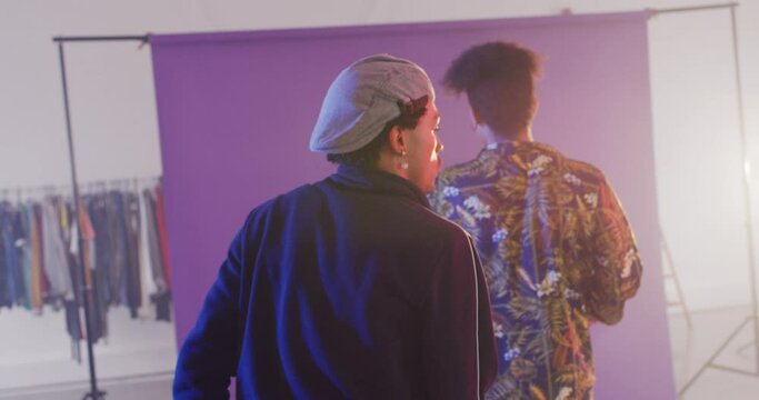 Happy biracial male dancers dancing together in dance studio, slow motion