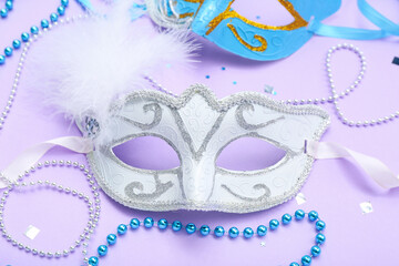 Carnival mask with beads and confetti on lilac background