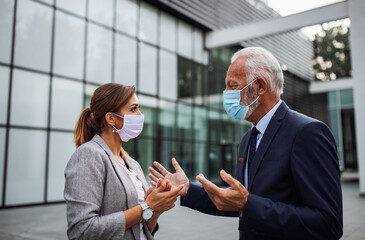 Business people wearing protective masks and talking - Powered by Adobe