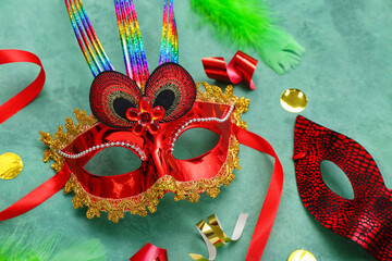 Carnival masks with confetti and serpentine on green background