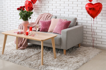 Interior of living room decorated for Valentine's Day with candles, roses and balloons