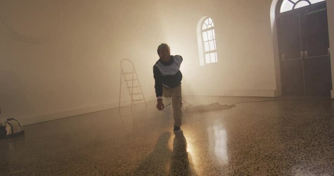 Portrait of biracial male dancer dancing in dance studio, slow motion