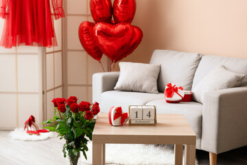 Calendar with date 14 FEBRUARY and gift on table in living room