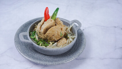 Delicious meatballs in wok pan on wooden background. Indonesian Food